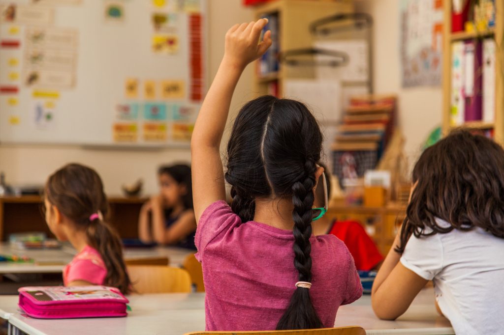 Kinder im Unterricht, ein Kind meldet sich